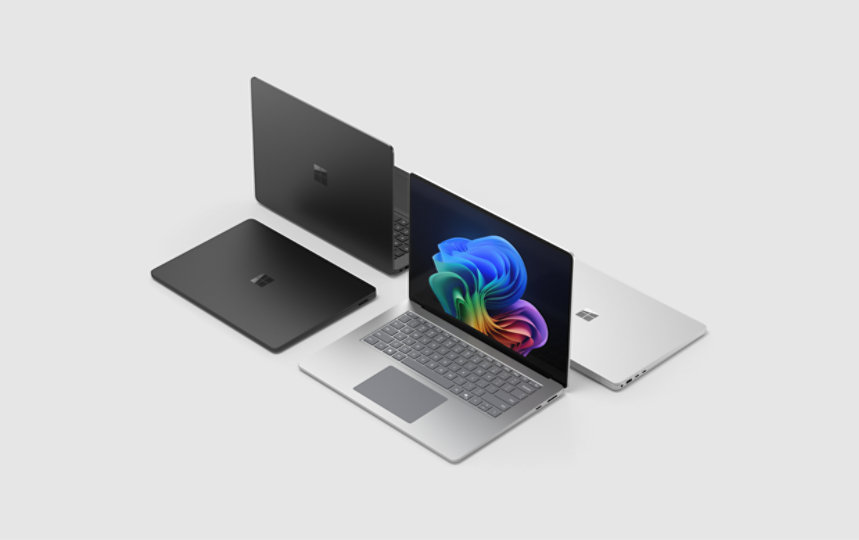 Two Surface laptops on a gray background, with one laptop displaying a Windows bloom background.