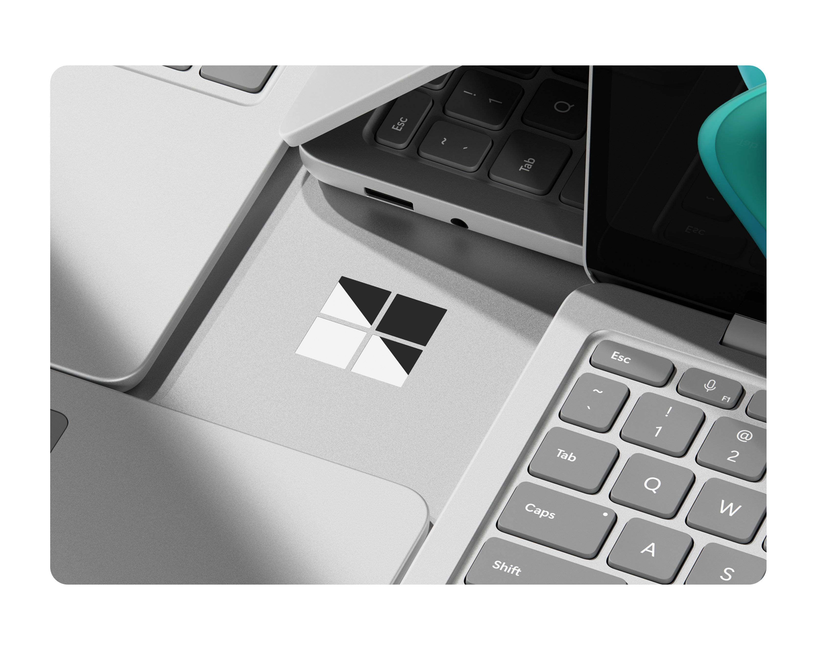 Close-up of four Surface Laptop Copilot+ PC laptops arranged together like tiles on a table, with a chrome Windows logo appearing in the middle of the group.