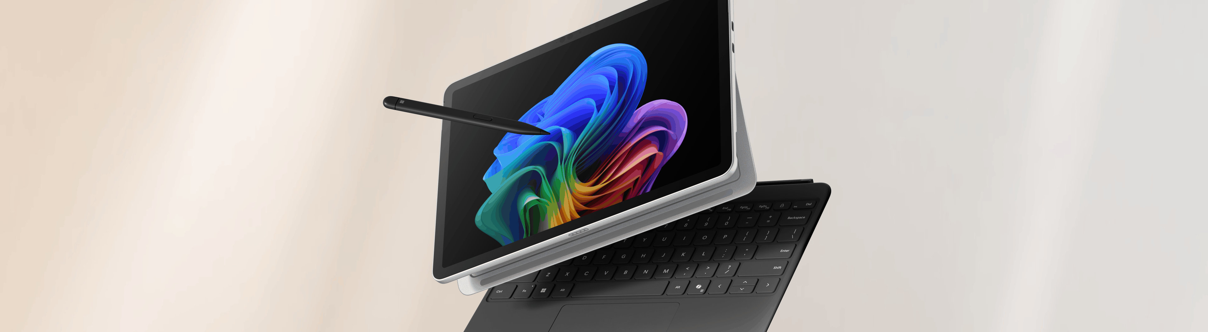 Surface 2-in-1 device with a Windows bloom background display on a peach and grey gradient background