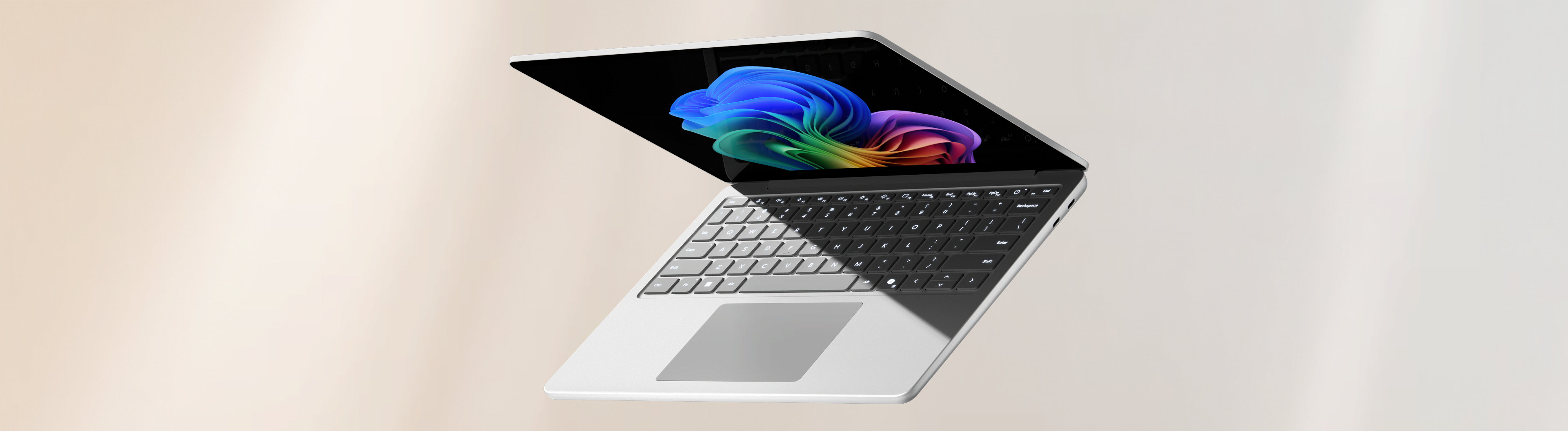 Open Surface laptop with a Windows bloom background display on a peach and grey gradient background