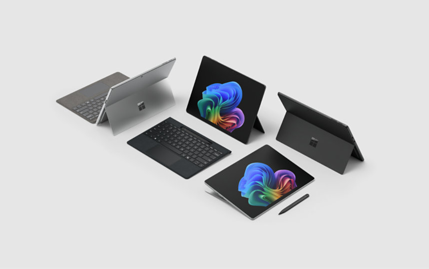 Five Surface devices with Windows bloom background displays on a gray background