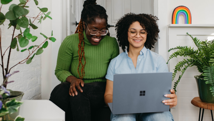 Two women use a Surface laptop at home