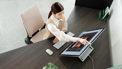 woman using Surface Laptop Studio 2 in office environment