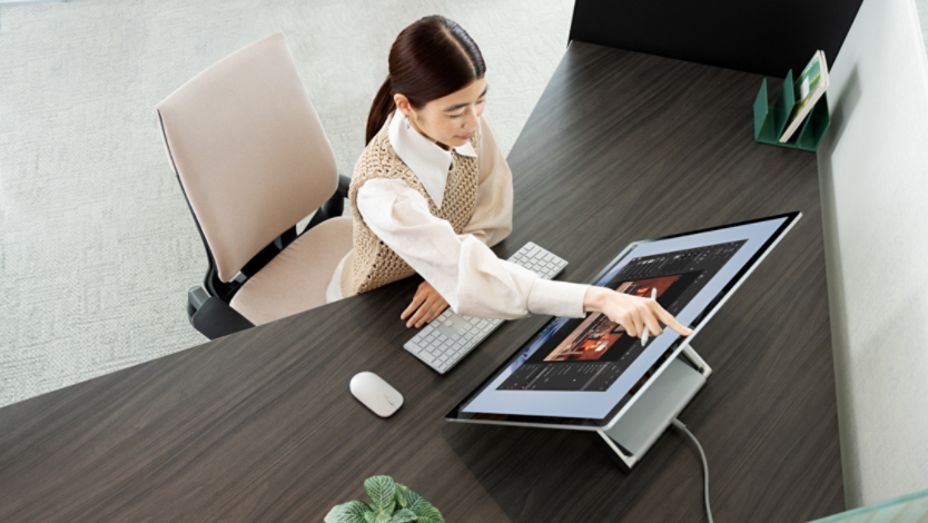 woman using Surface Laptop Studio 2 in office environment