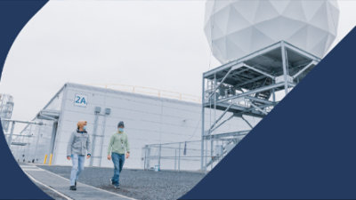 Des personnes qui marchent devant un bâtiment blanc