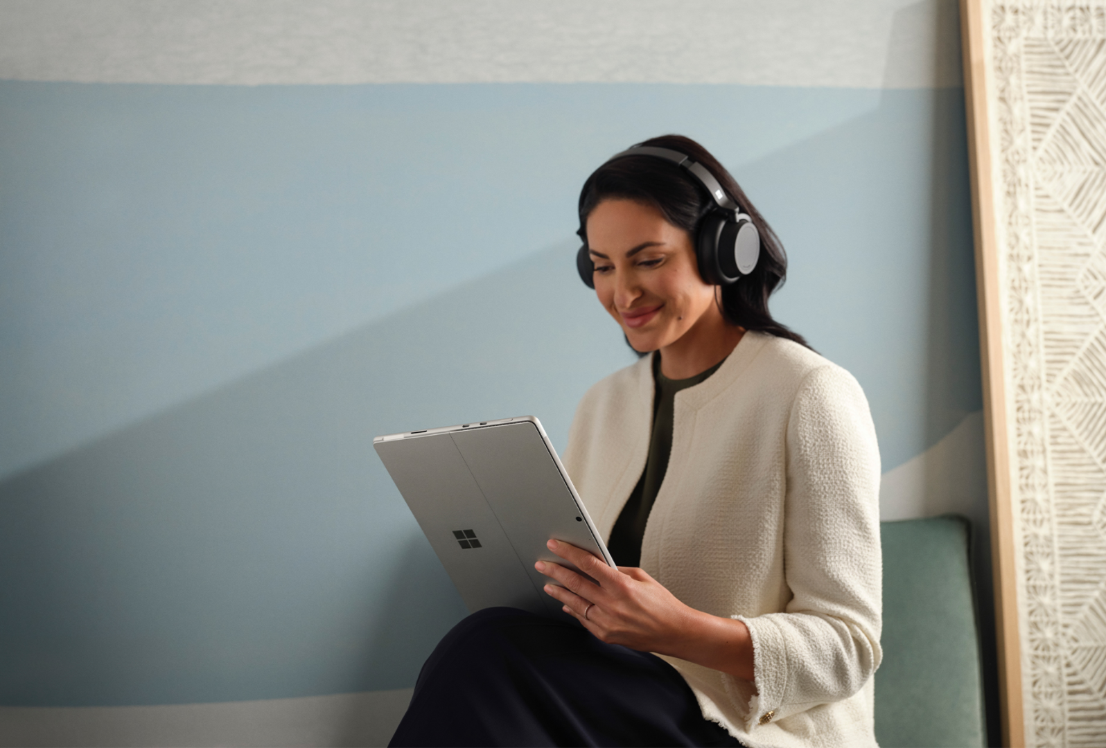 يظهر شخص يضع سماعة الرأس Surface Headphones 2+‎