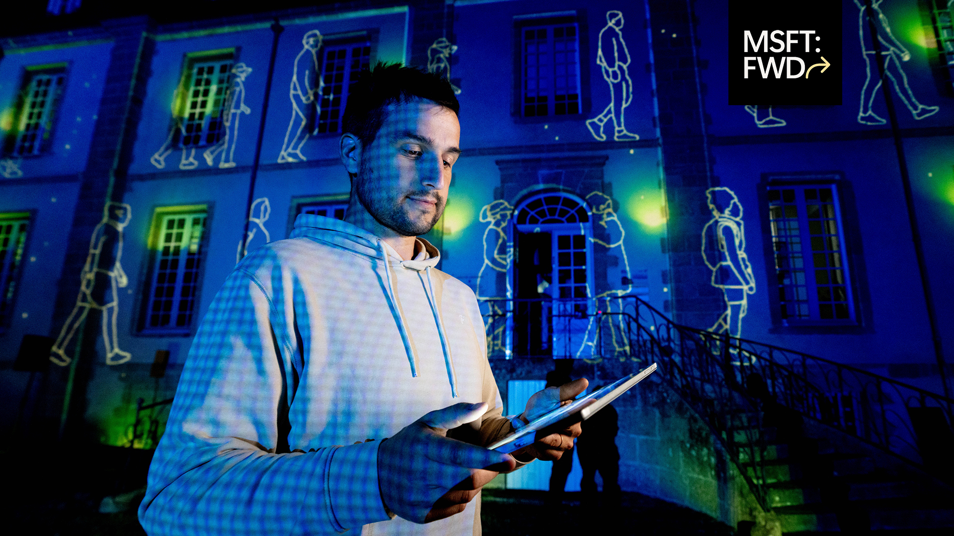 Creative technologist Philippe Dubost works with Surface Pro to prepare a vibrant light projection show in the background