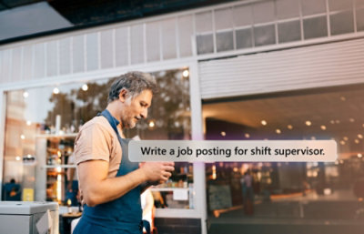 Man in apron, using Copilot on his phone to update a job posting