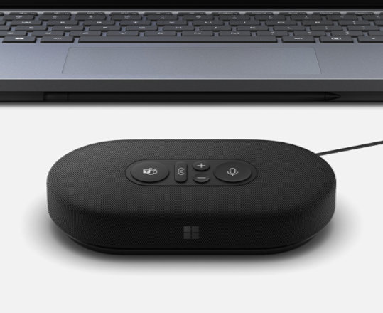 A render of Microsoft Modern USB-C Speaker plugged into a Surface device in the background