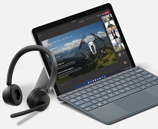 A render of a Microsoft Modern Wireless Headset leaning against a Surface device