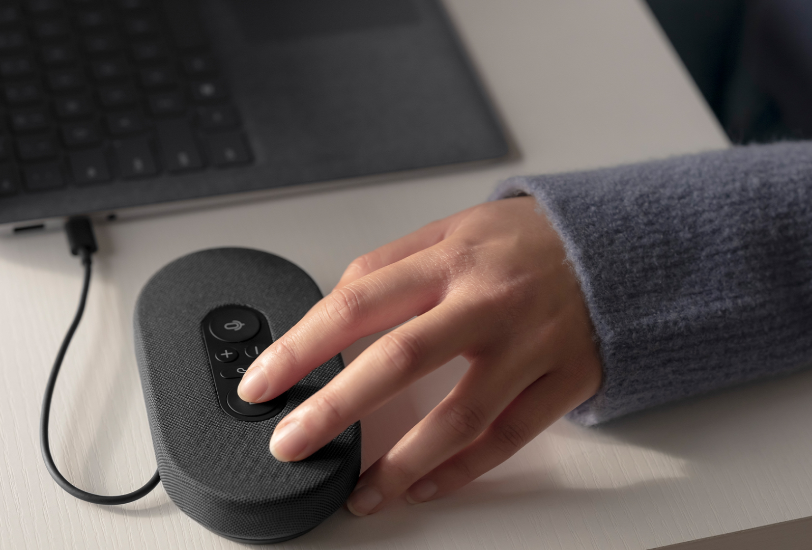 A person's hand is observed using the Microsoft USB-C Speaker to initiate a Microsoft Teams call