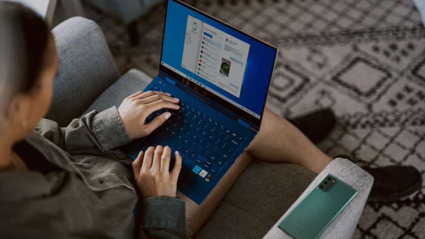 Person sitting on couch using Windows laptop