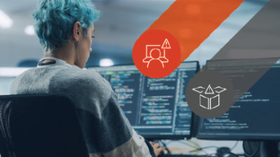 En kvinne som sitter ved en datamaskin med to skjermer foran seg.