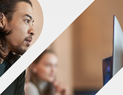 Mies ja nainen istuvat pöydän ääressä ja käyttävät kannettavaa tietokonetta.