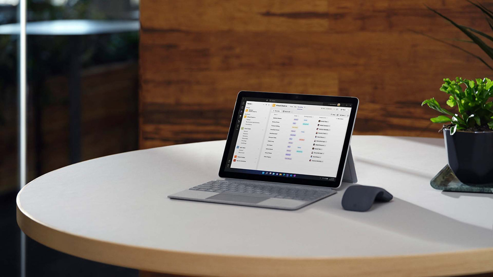 Surface Go 3 med Surface Arc Mouse som sitter på ett bord på kontoret
