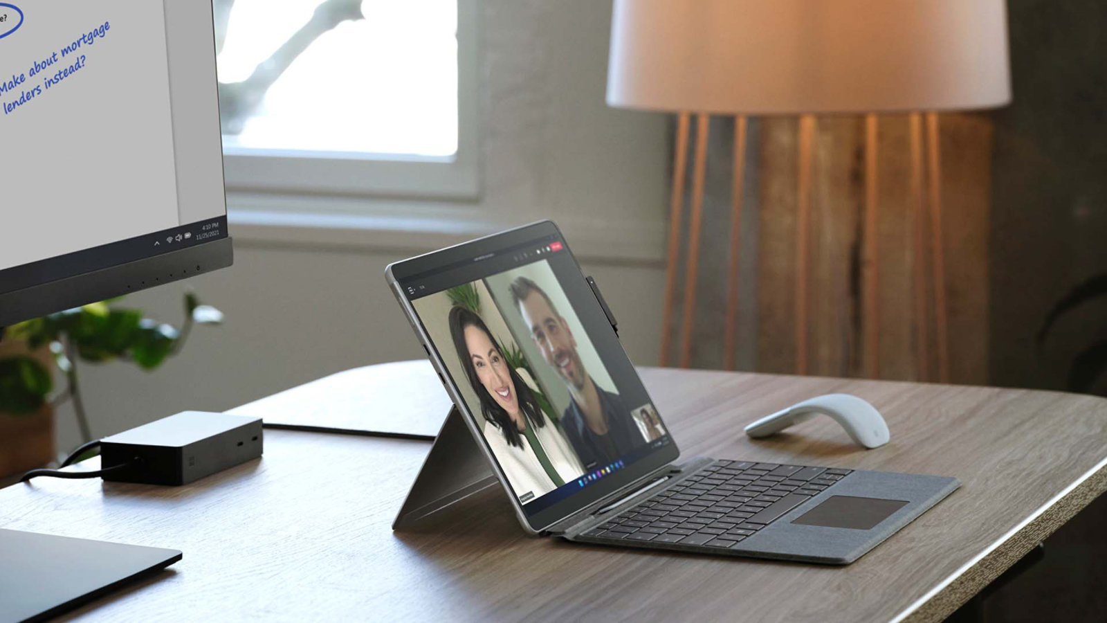 Surface Pro X neben einer Surface Arc Mouse auf einem Schreibtisch in einer Büroumgebung
