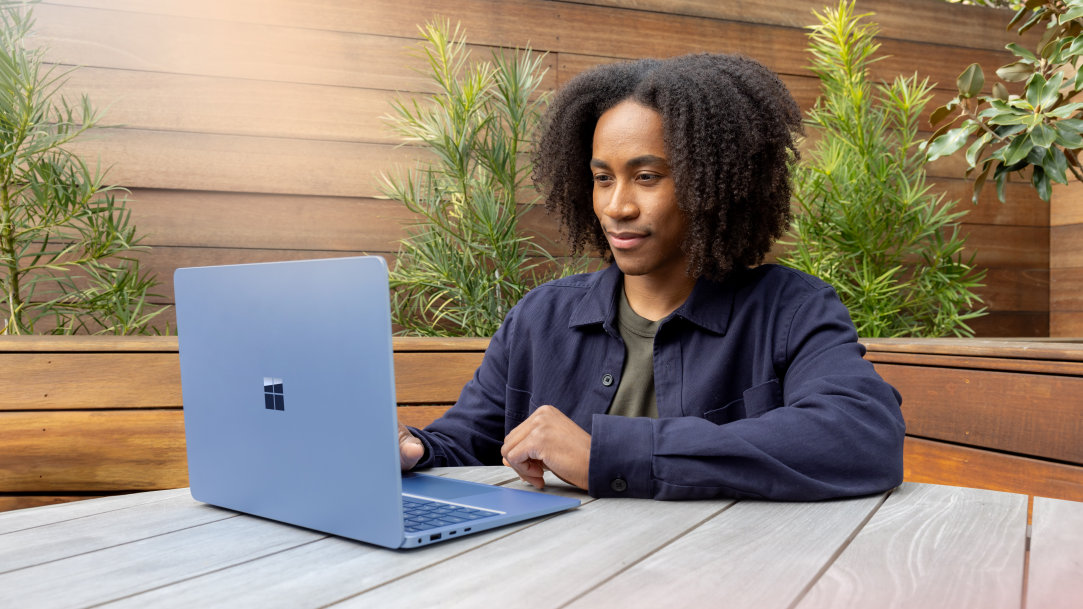 A man using a Windows 11 laptop