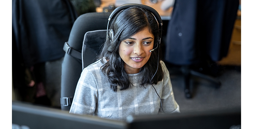 A customer service representative wearing a headset and smiling