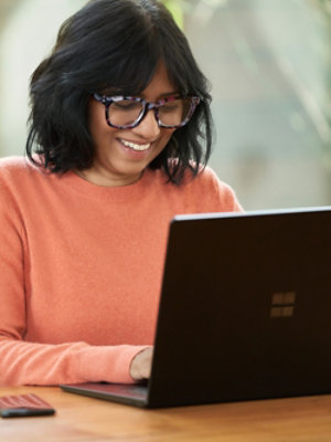 A woman wearing glasses and smiling.