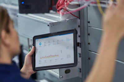 Hands holding a tablet displaying automated operations in Azure