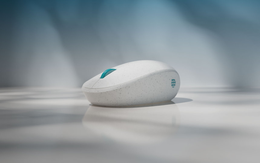 Zbliżenie na mysz Microsoft Ocean Plastic Mouse z szarymi plamkami i kółkiem do przewijania w kolorze turkusowym.