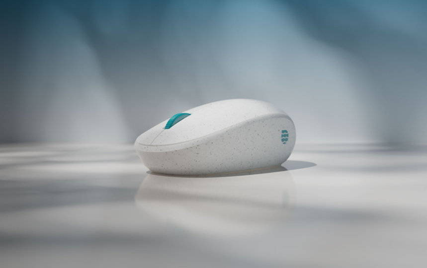 Close up view of the Microsoft Ocean Plastic Mouse featuring grey speckles a turquoise finger dial.