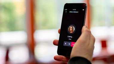 Eine Hand, die ein Mobiltelefon hält und einen Anruf in Teams tätigt.