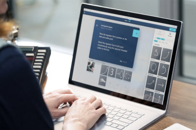 Hands typing on a laptop that is displaying a fuel injection system
