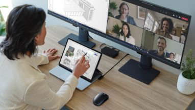 Eine Person in einem Teams-Videoanruf mit einem Tablet, das mit zwei Desktopmonitoren verbunden ist.