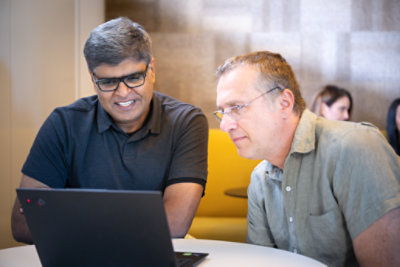 Two people looking at the laptop
