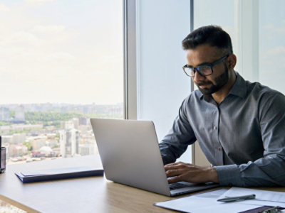 A person sitting at a desk using a laptop.