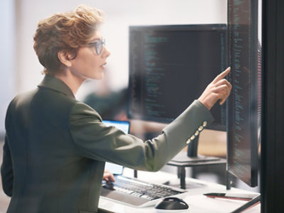 A person pointing at a computer screen.
