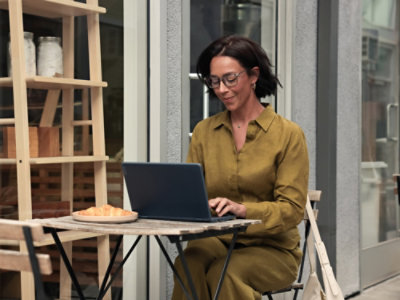 A person sitting at a table using a laptop.