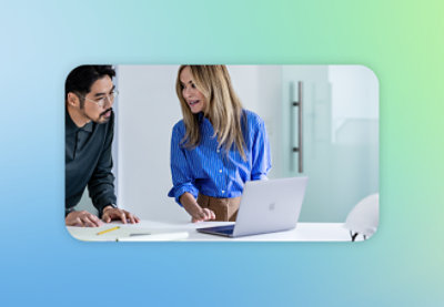 一位男士和一位女士看着笔记本电脑。