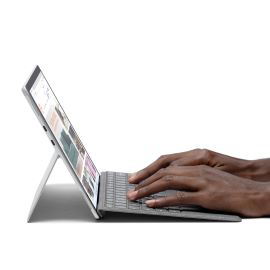 Hands typing on a Surface Pro X device and Keyboard.