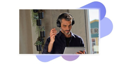 Una persona con audífonos de diadema sostiene una tableta.