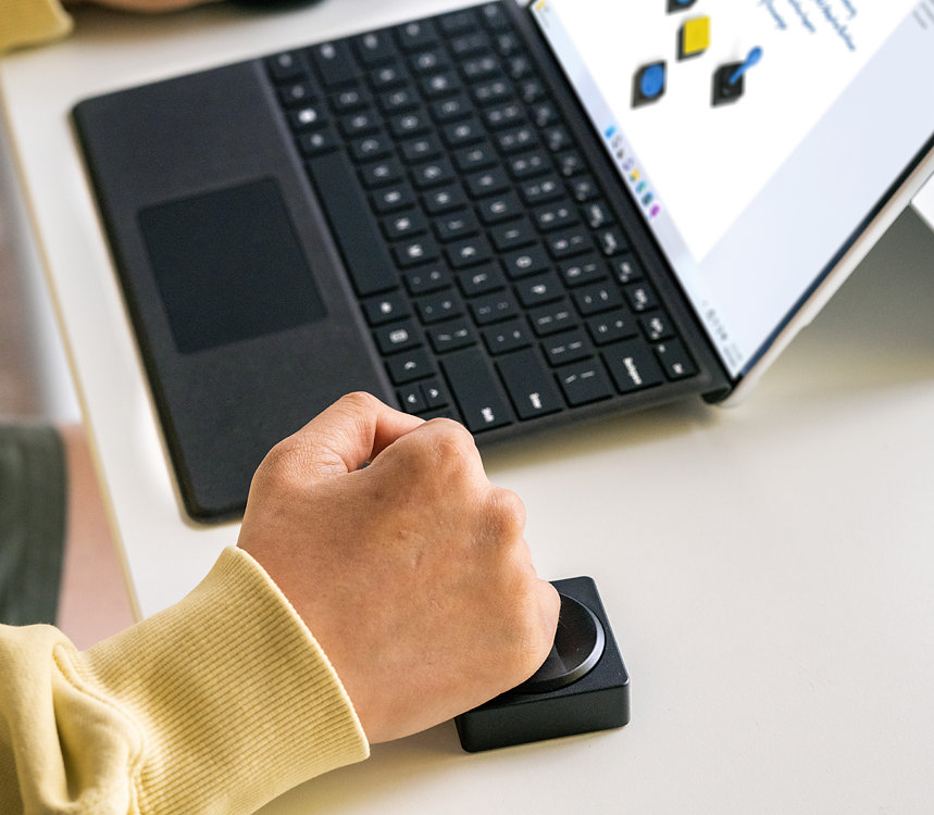 Una persona usa el botón de cruceta adaptable de Microsoft con su dispositivo Surface.