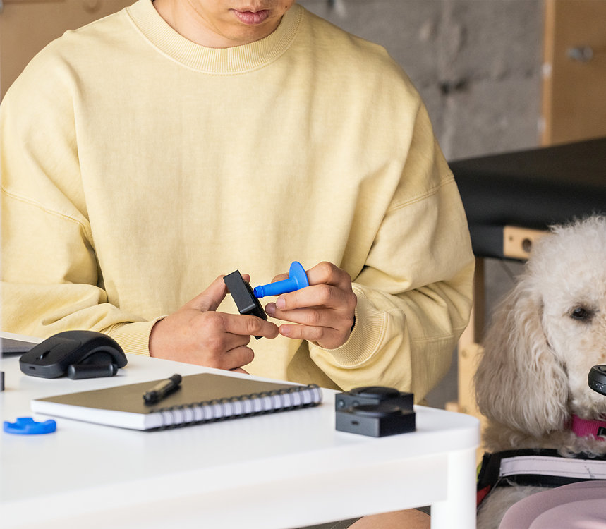 Une personne attache un capuchon de bouton au bouton Accessoires adaptatifs Microsoft