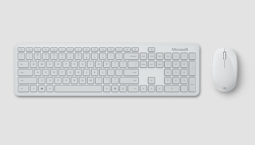 A hand upon an ergonomic Microsoft keyboard and Microsoft Bluetooth® Mouse.