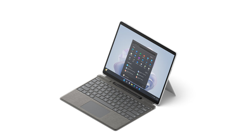 Surface Pro 9 shown from a 3/4 view with attached type cover and Surface Slim Pen 2.