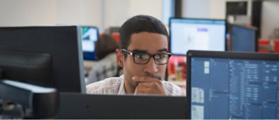 Person looking at a laptop, wearing glasses