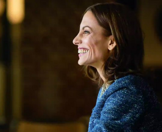 Eine lachende Frau mit ihrem Laptop auf dem Tisch