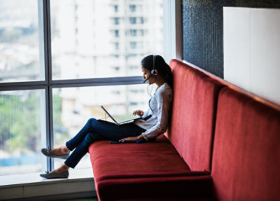A person sitting on a couch with a computer