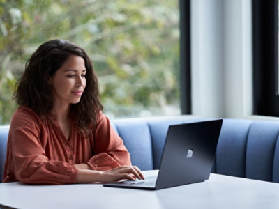 A woman sitting at a table using a laptop.