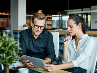 A person and person looking at a tablet