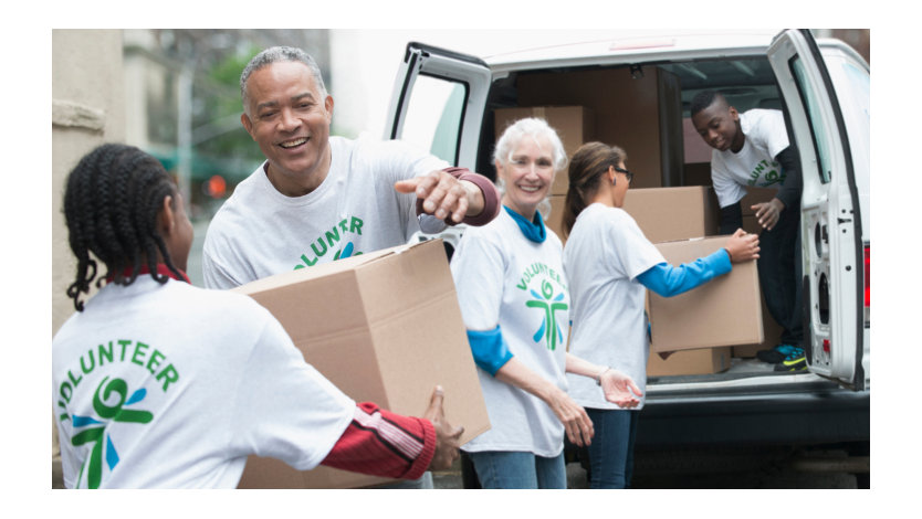 En gruppe av frivillige som bærer ut pappkartonger fra en varebil