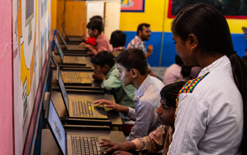 An instructor oversees young people in a computer lab.