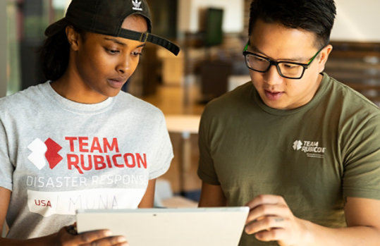 Team Rubicon crew members looking at a tablet together.