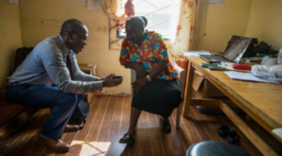 A person demonstrating something on his mobile phone to another person