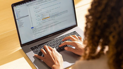 A developer coding on a laptop computer